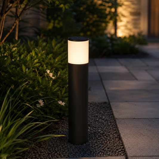 Matte black solar bollard path light glowing beside garden walkway at night - image 1